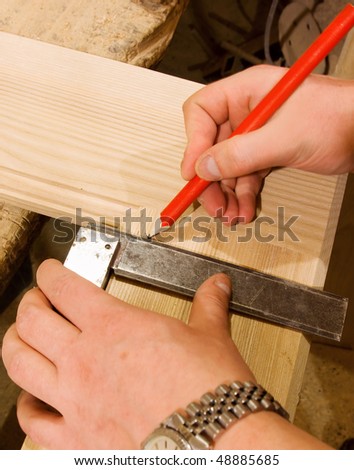carpenter hand with square and pencil