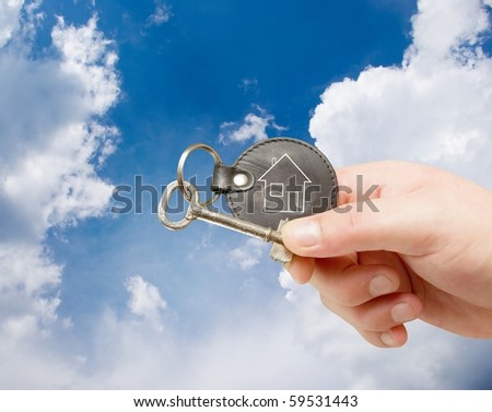 key chain in human hand on sky background