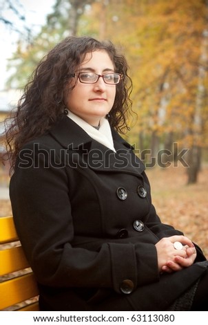 young woman sitting on bench. Autumn theme