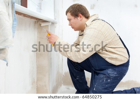 Man painting wall with roller