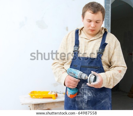 tired worker with mobile drill in hand. House improvement theme