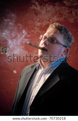 smoking man in black suite on red wall