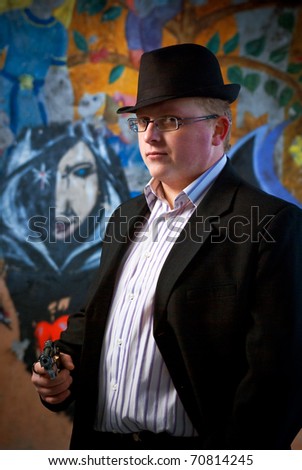 man in suit with gun on graffiti background