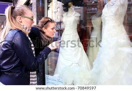 stock photo Two young girls are considering wedding dresses in a shop 
