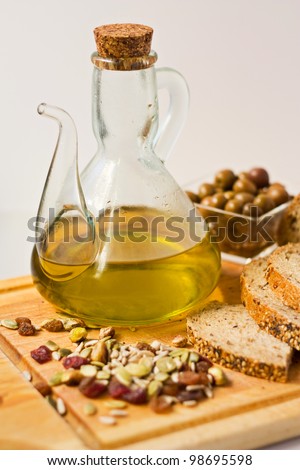 Olive oil in jug, olives, bread and dried fruit