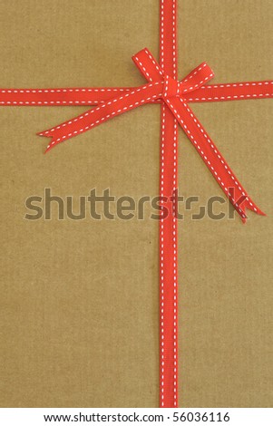Red ribbon and bow on cardboard as background