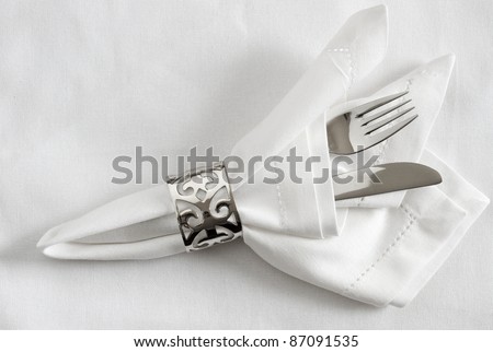 Table place setting with silver napkin ring, napkin and cutlery