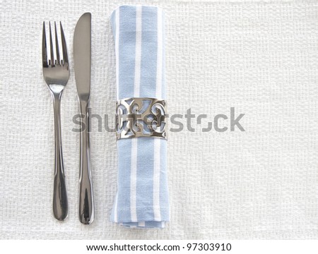 Table setting with blue and white striped napkin and knife and fork with space for text