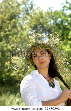 young woman  in the forest with diadem with wild flowers on