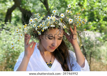 young woman in the forest with diadem with wild flowers on