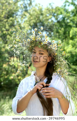 young woman  in the forest with diadem with wild flowers on