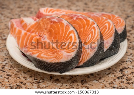 Raw fillet of fresh salmon fish on white plate