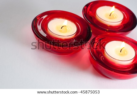 three red candles isolated on a light background