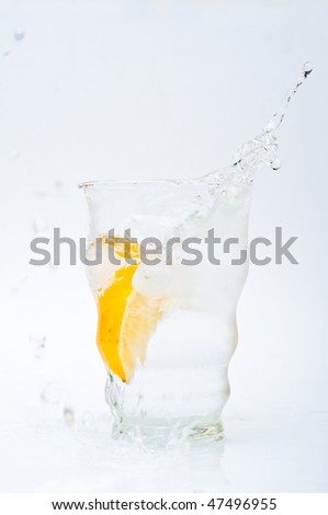Glass of water with ice and a slice of lemon isolated
