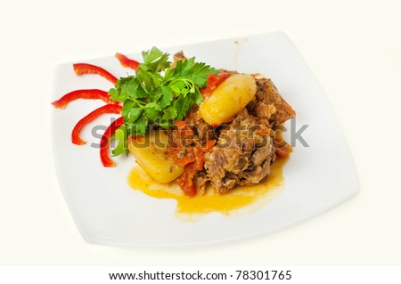 meat with potatoes, against white background closeup