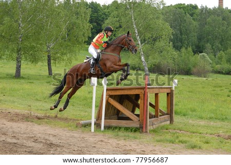 MOSCOW - JUNE 06: Rider horseback jumps through an obstacle on a Russian Cross-Country Championship, CIC 2* on June 06, 2009 in Moscow.