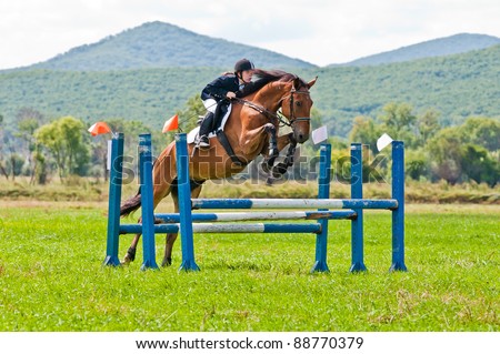 ARSENEV, RUSSIA - SEPTEMBER 03: Unidentified child-rider in action jumps over a hurdle at horse on the show jumps \