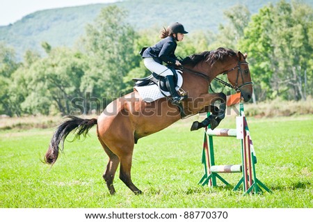 ARSENEV, RUSSIA - SEPTEMBER 03: Unidentified child-rider in action jumps over a hurdle at horse on the show jumps \