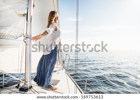 woman staying on the sailboat during sunset