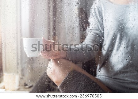 Young woman with cup throw the rain drops