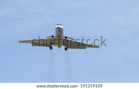 Private jet on landing approach with vapor trails