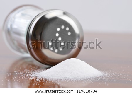 Salt spilling on table from salt cellar