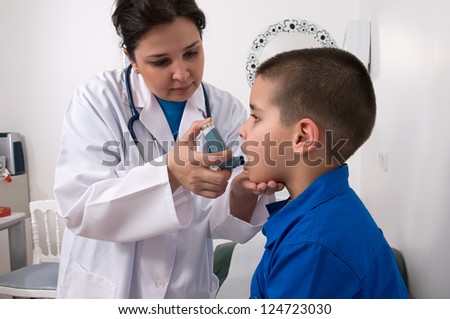 Medical doctor applying oxygen treatment on a little boy with asthma