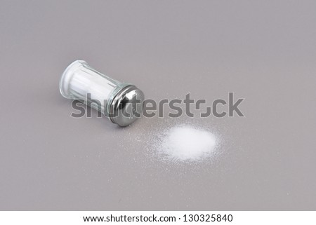 Salt spilling from glass salt shaker