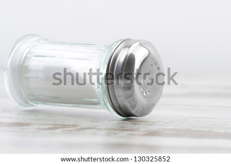 Salt spilling from glass salt shaker