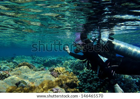 Female diver taking film underwater