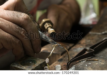 Jeweler melting gold bracelet with gasoline burner for making jewelry