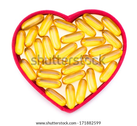 Fish oil pills in red heart shaped box isolated on white background