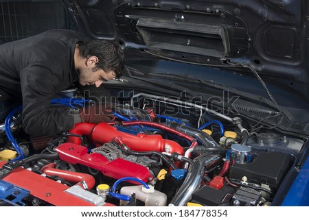 Car repairman examining modified rally car