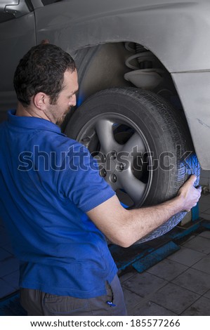 Car repairman changing flat tire
