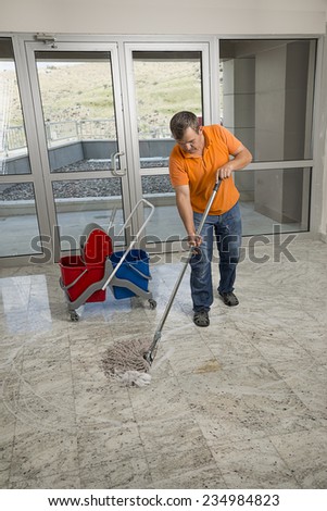 Manual worker mopping the floor.