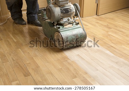 Wood floor polishing maintenance work by grinding machine.