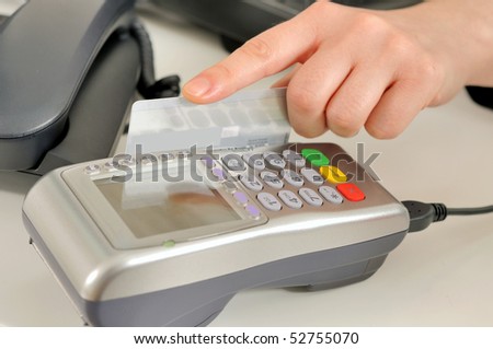Hand with credit card swipe through terminal for sale.