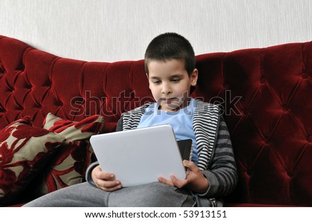 Boy watching portable DVD player in a cafe.