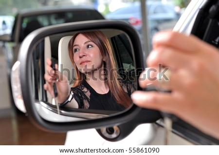 Reflection of a red head woman buying a new car - a series of BUYING A NEW CAR images.