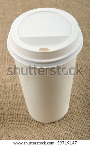 Beige disposable coffee cup on canvas.