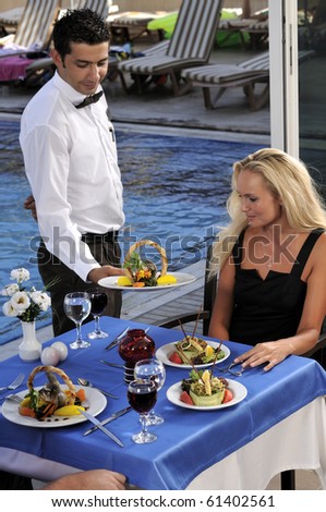 Attractive woman at a restaurat having dinner being served by a waiter - a series of RESTAURANT images.