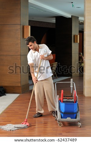 Young housekeeper mobbing the floor - a series of HOTEL images.