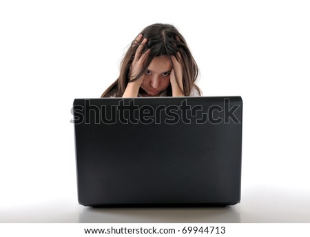 Teen girl frustrated behind a laptop isolated on white background - see more computer images.