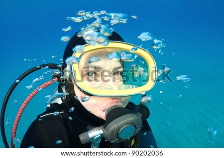 Scuba diver with bubbles looking at copy space for your text.