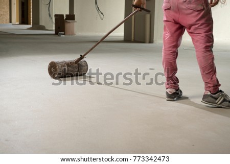 Manual worker pressing vinyl floor with pust roller.