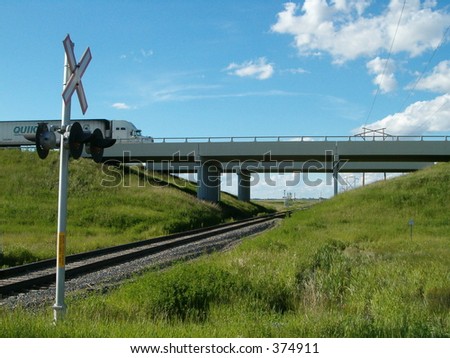 highway bridge over train tracks with crossing lights