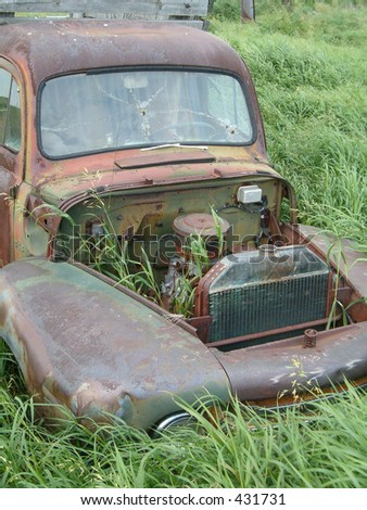 rusty old truck body in deep grass