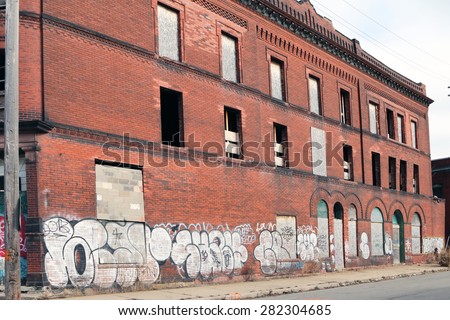 DETROIT, MI-MAY, 2015:  Abandoned apartment building with graffiti on the side of the building near downtown Detroit.