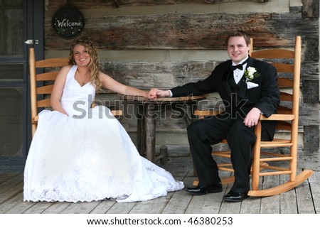 Wedding couple sitting on porch of a log cabin