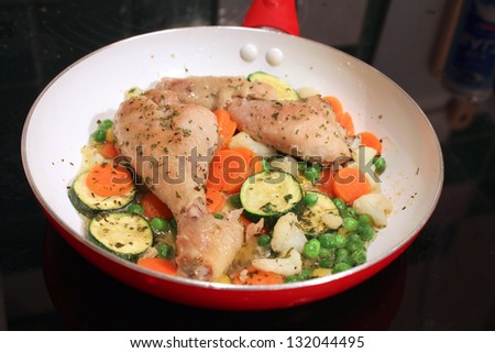 Chicken legs in vegetables braised on ceramic pan. Healthy food